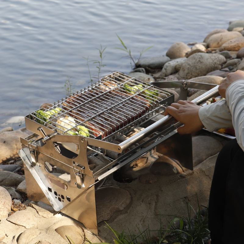 Portable folding BBQ grill set up at scenic outdoor camping site
